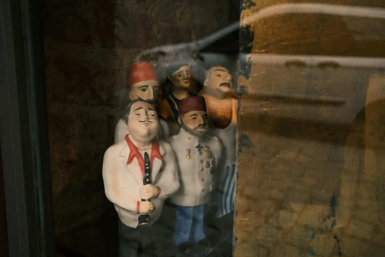 a small group of figurines on the window of a store