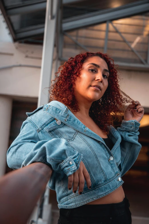 a young woman is standing against the wall