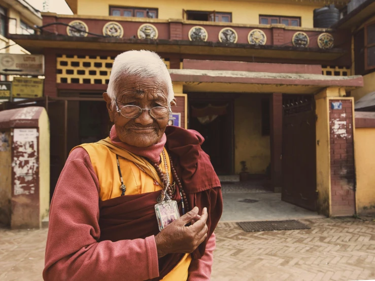 an elderly man standing in front of a building