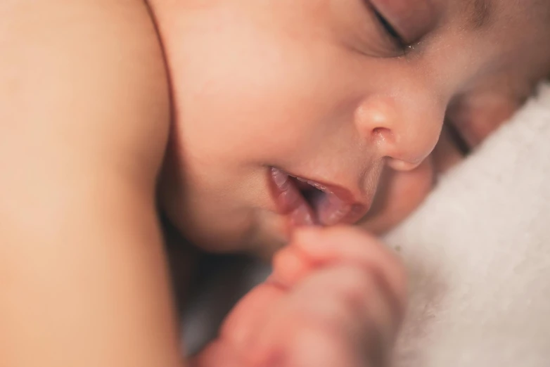 a close up of a baby sleeping on a blanket