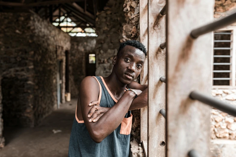 man posing for picture in front of brick wall