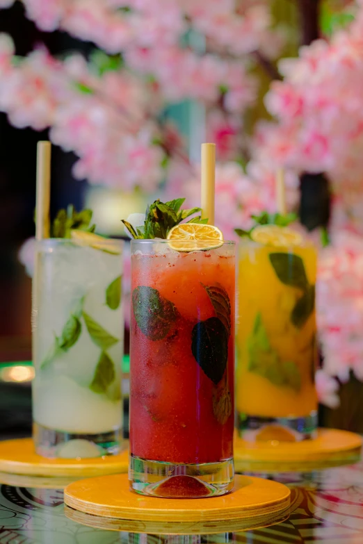 four different colored drinks on a yellow plate