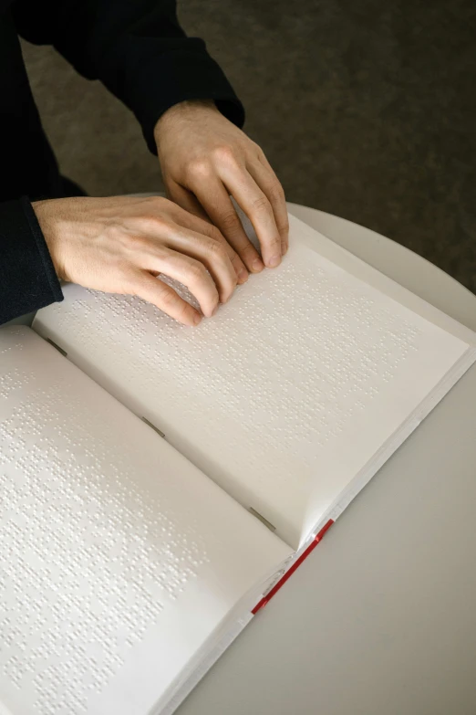 a man is holding on to a book with two fingers