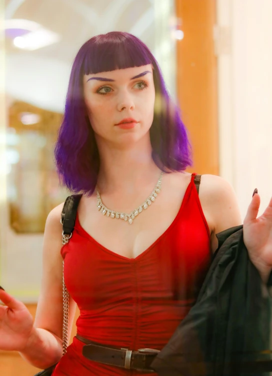 a woman with purple hair and wearing a red dress