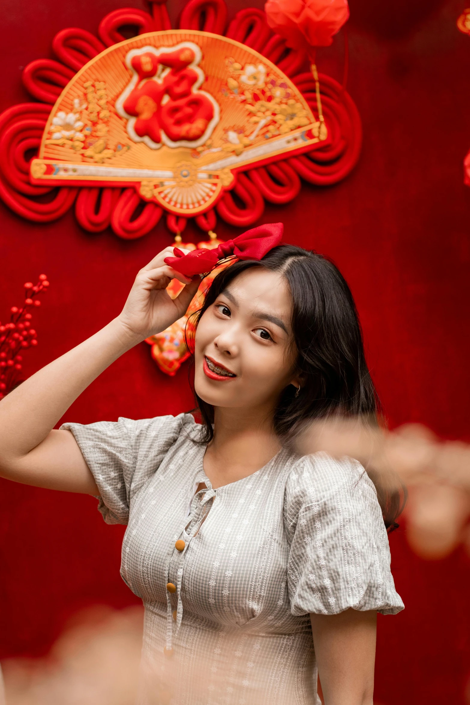 a young woman adjusts her red bow at a traditional chinese dance