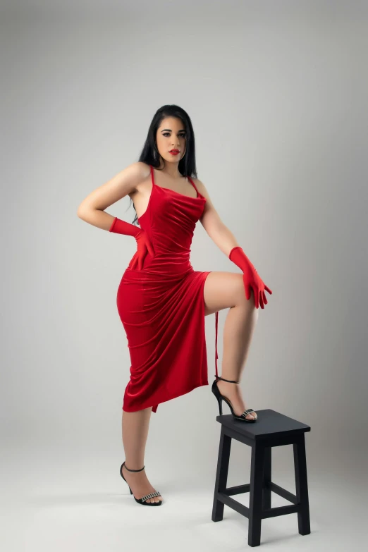 woman in red dress with legs on stool