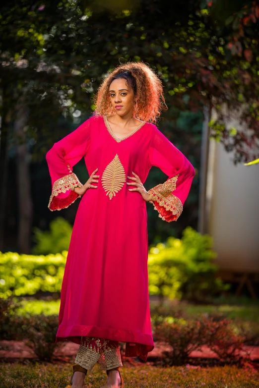 a young woman dressed in pink poses for the camera