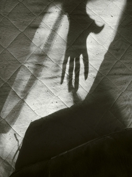 a person casting a shadow with their arm over an opened suitcase