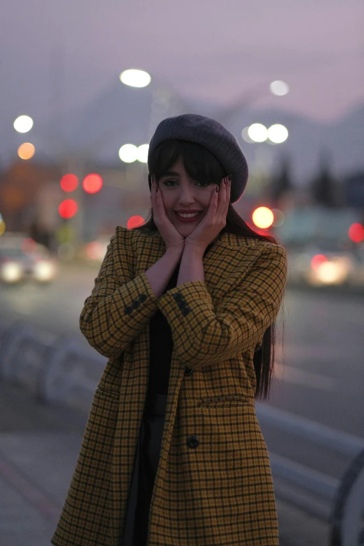 a woman standing on a street corner smiling