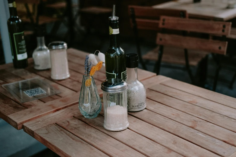 several bottles on top of a table with empty wine glasses and salt and pepper shakers