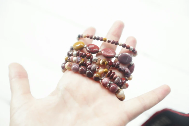 a person with their hand holding a bunch of beads