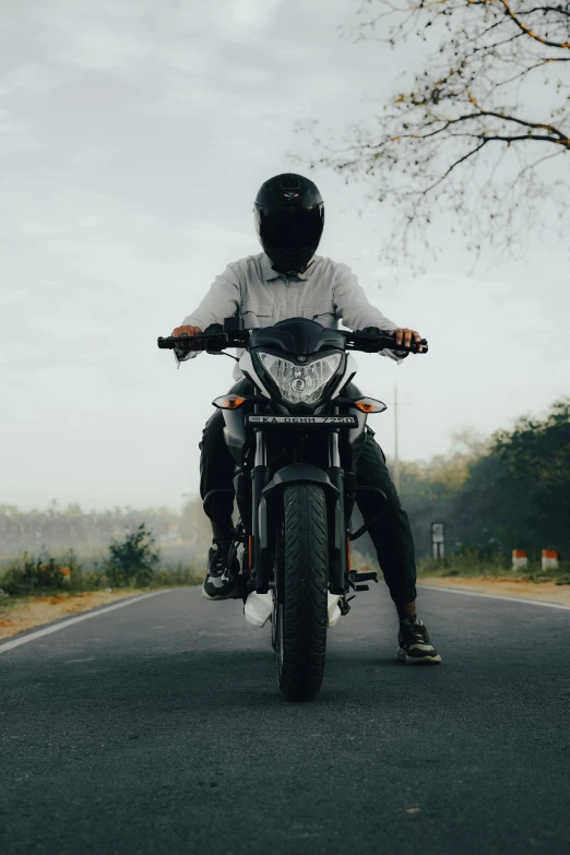 a man on a motorcycle that is sitting down on a street