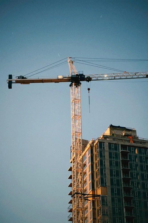 some building cranes and buildings under a blue sky