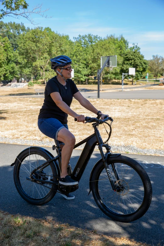 a woman riding a bicycle across a park