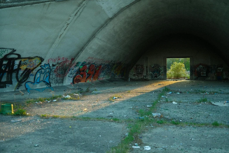 an open tunnel covered in graffiti with a doorway