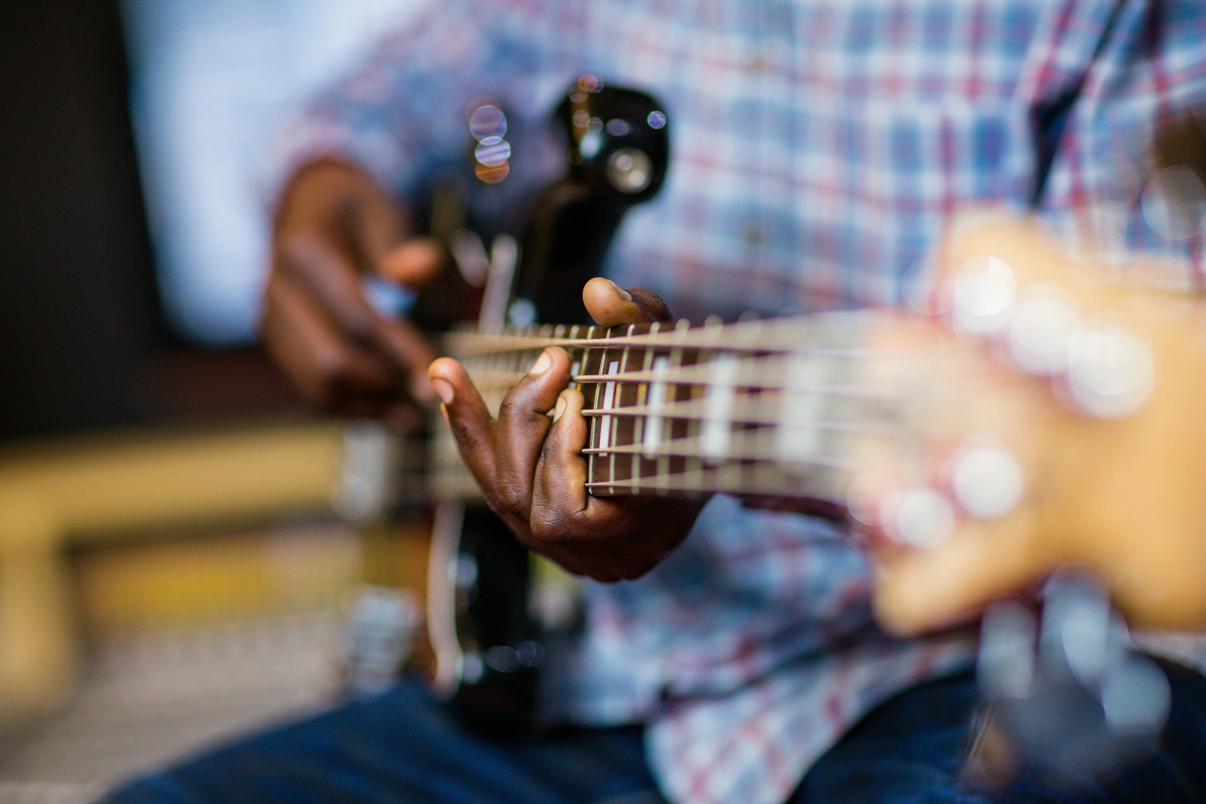 a man with a guitar playing it with his hand