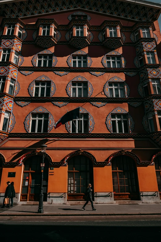 the corner of an old building with people walking on the sidewalk