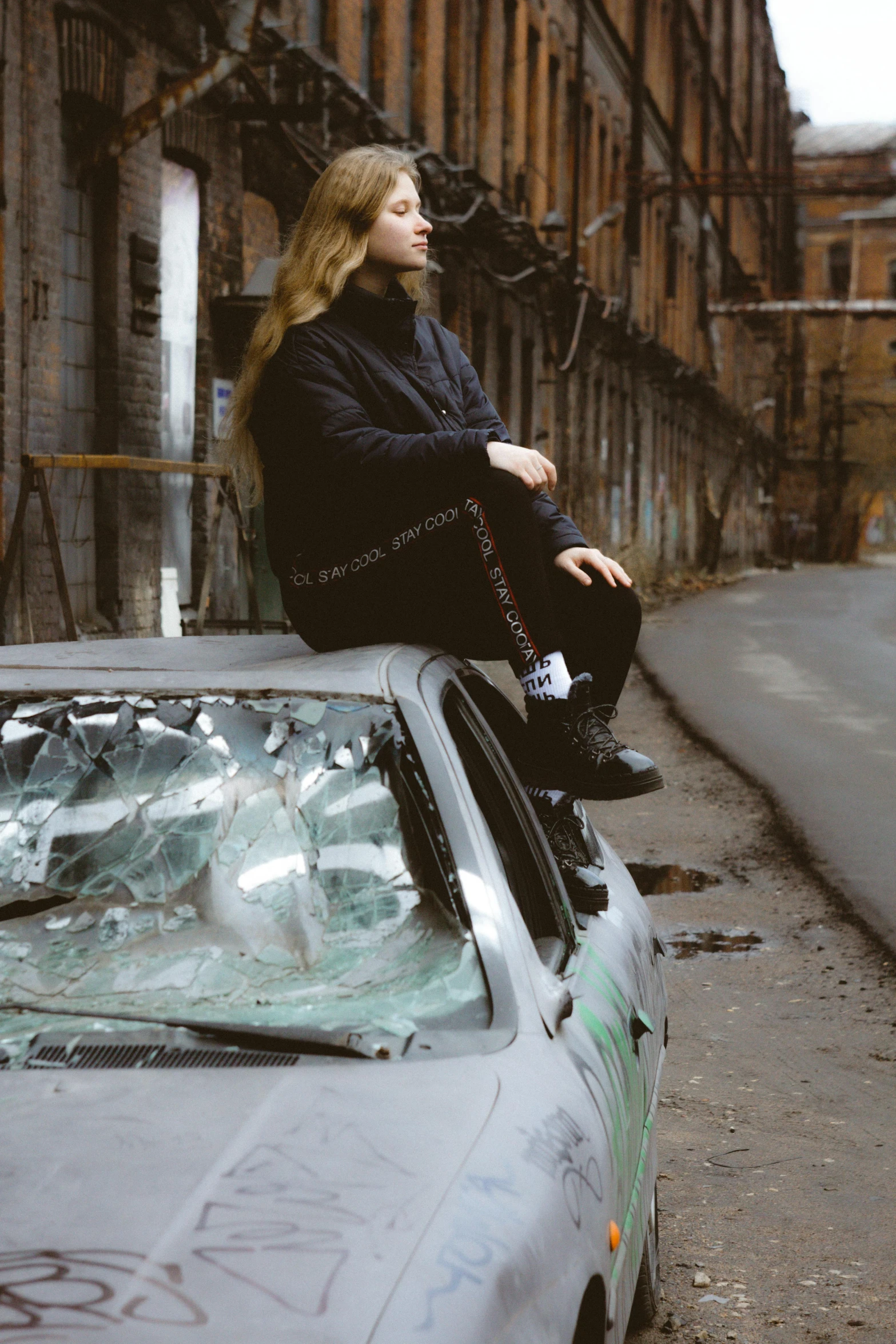 a woman sitting on top of the top of a car