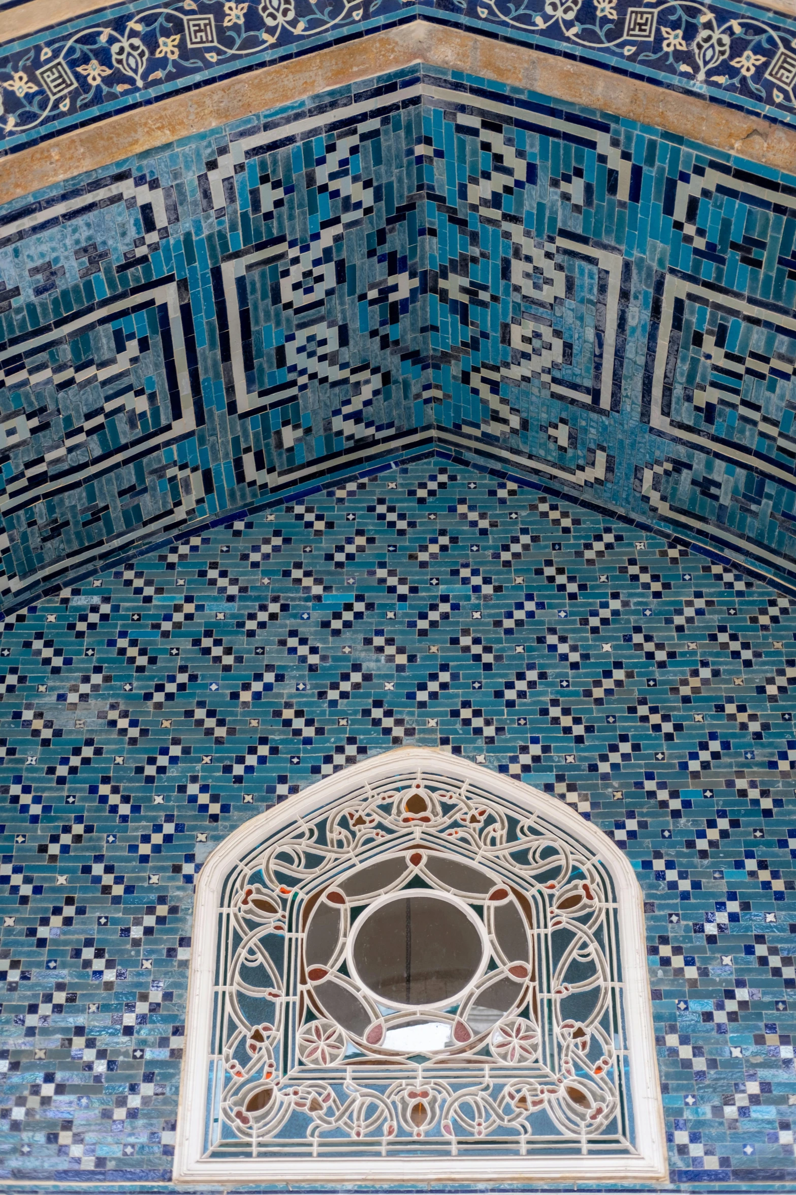 a decorative arch above a mosaic tiled wall