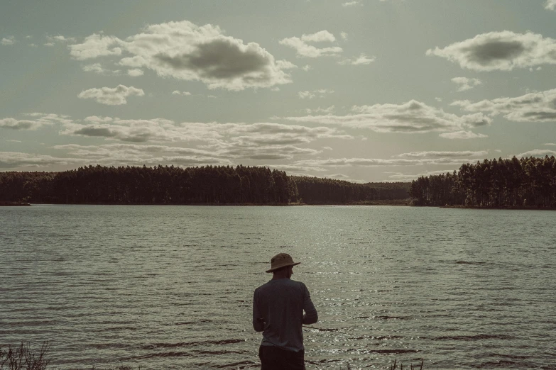 a person standing in the water near a lake