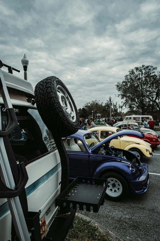 a row of colorful cars are stacked high in the parking lot