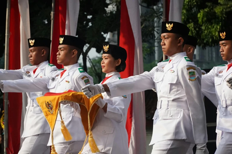 military men and women in white uniforms performing on stage