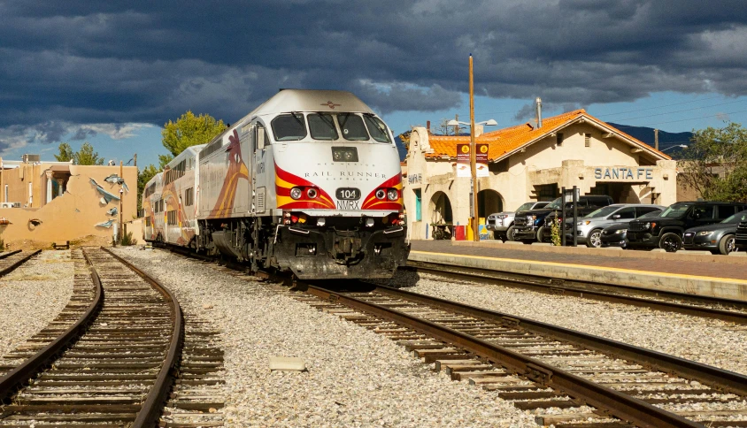 train traveling down the tracks next to an empty station