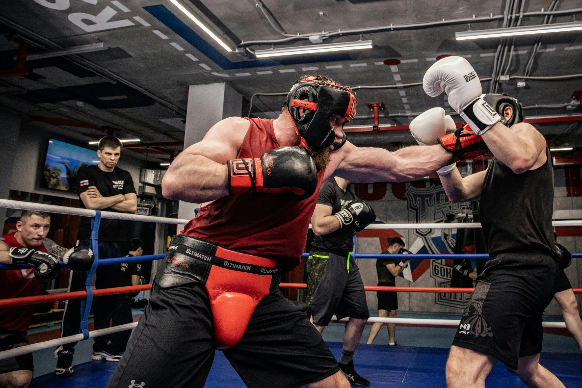 two men fighting with each other while standing in an arena