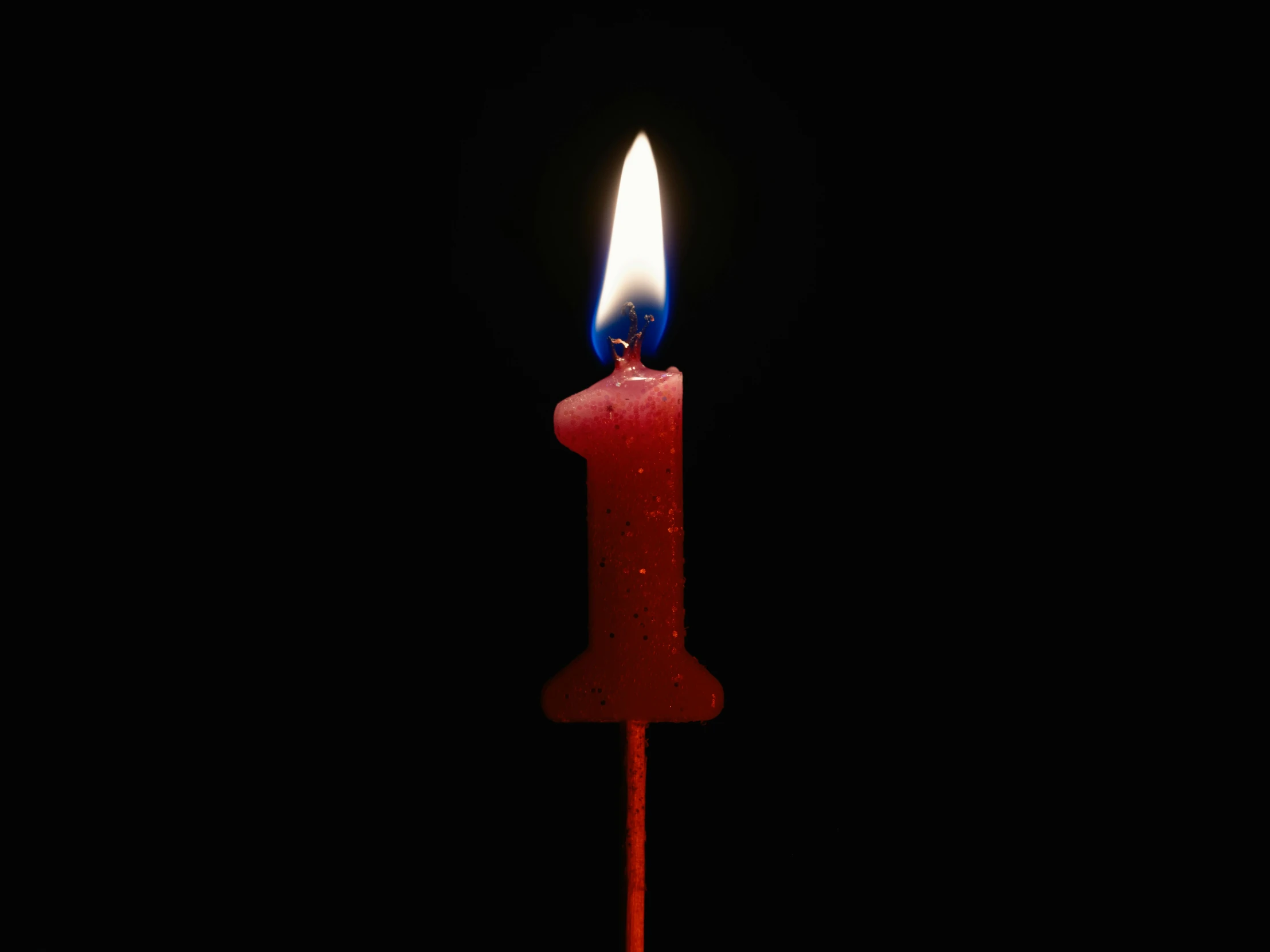 a candle sitting in the middle of a black surface