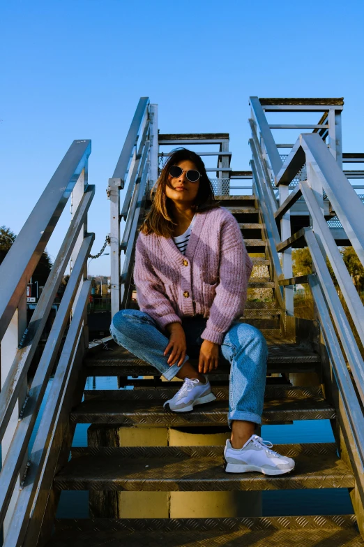 a young woman sitting on the steps of stairs