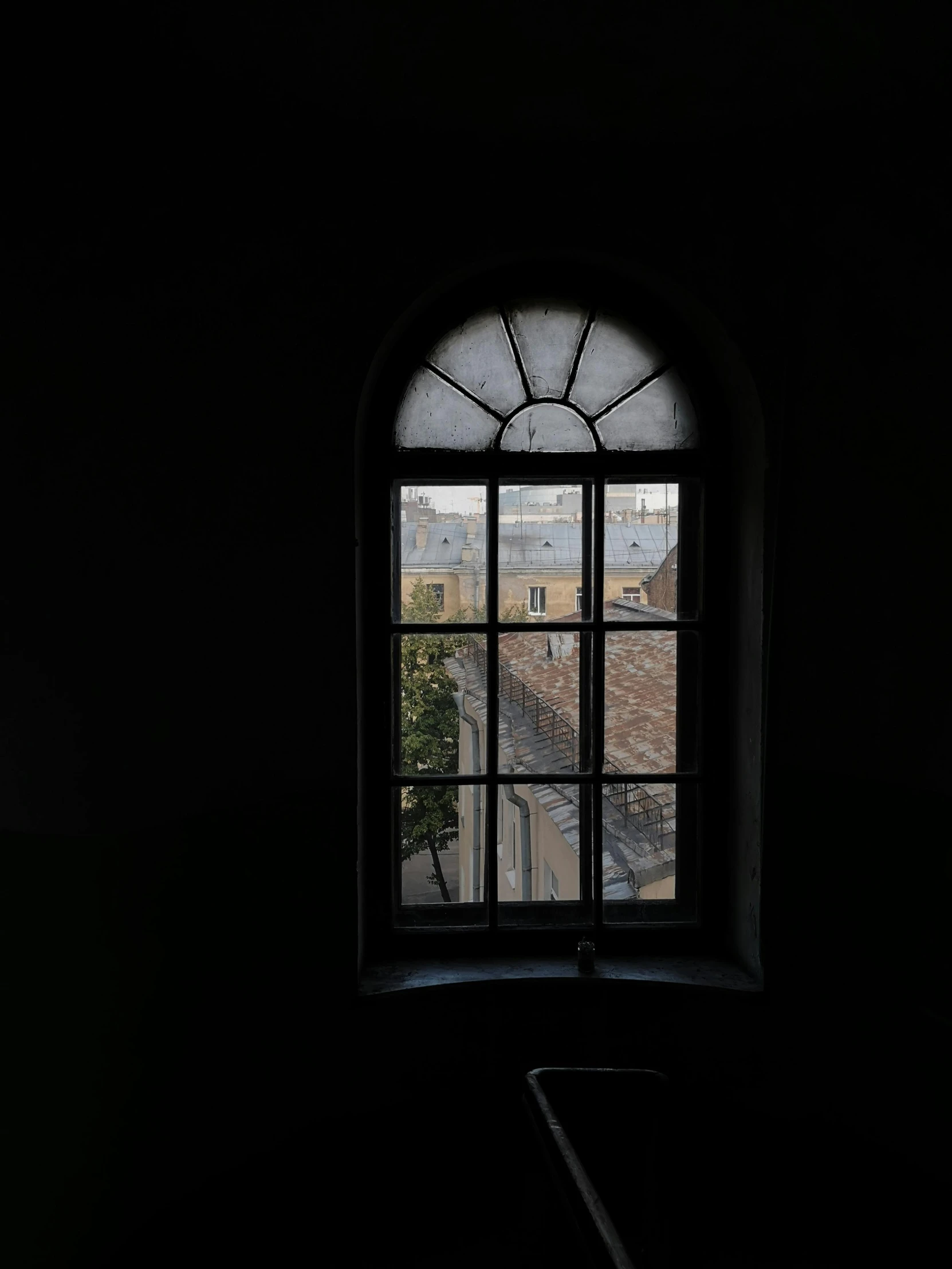 a view out a window in an old building, looking out at some buildings