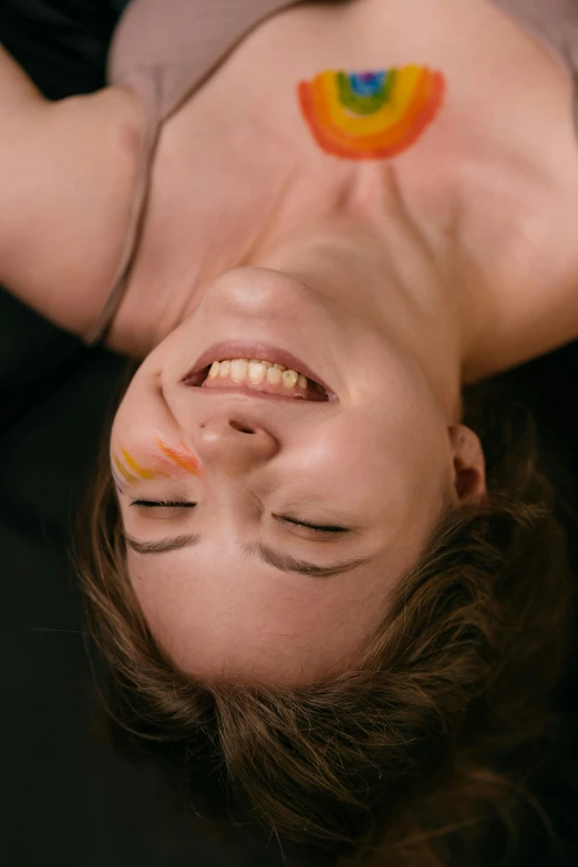 a woman with makeup paints laying on her face