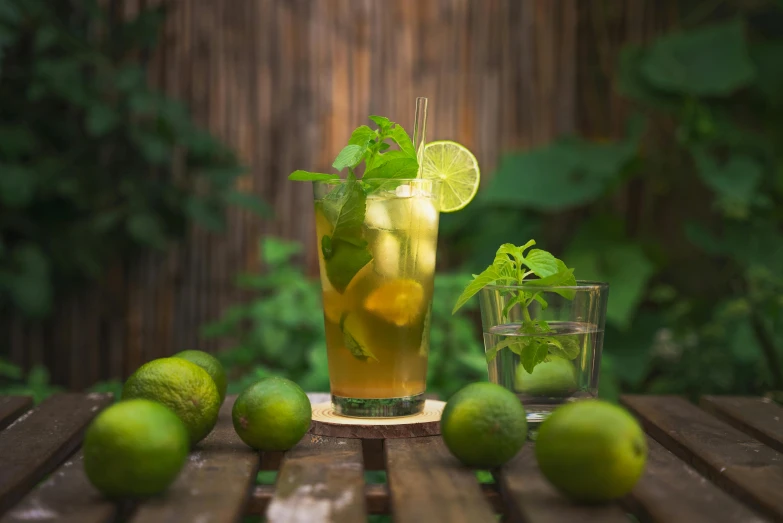 limes and water are arranged on a wooden table