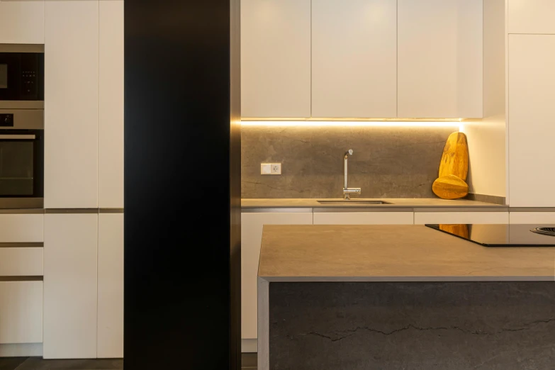 a modern kitchen with a yellow vase in the center