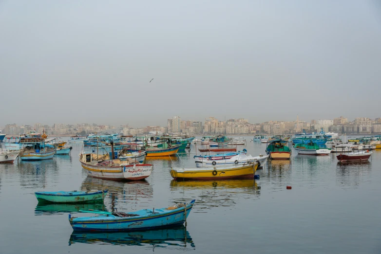 many boats are anchored on the water in this small city