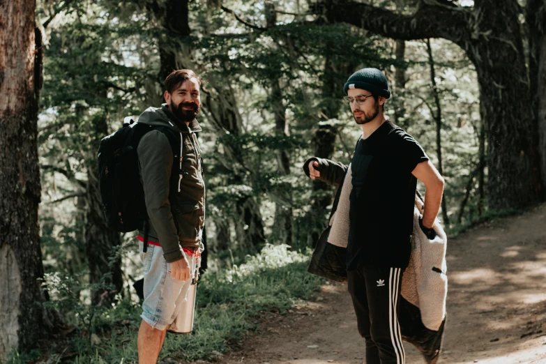 two men in the woods one is wearing a backpack