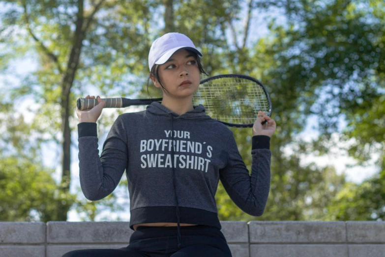 young female tennis player holding a racket with both hands