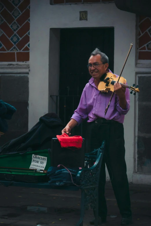 an old man is playing music on the street