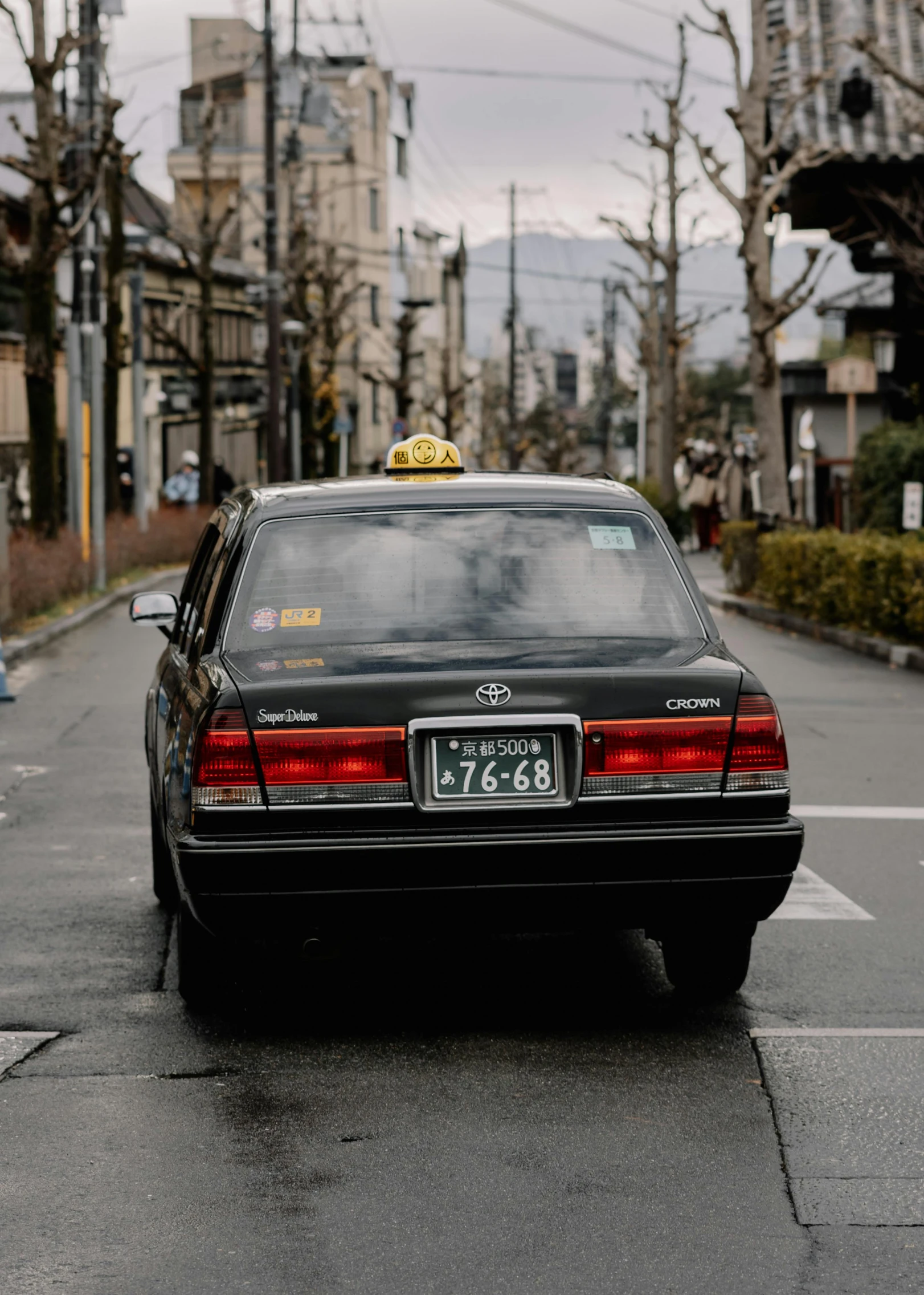 an old black car with yellow taxi number plate