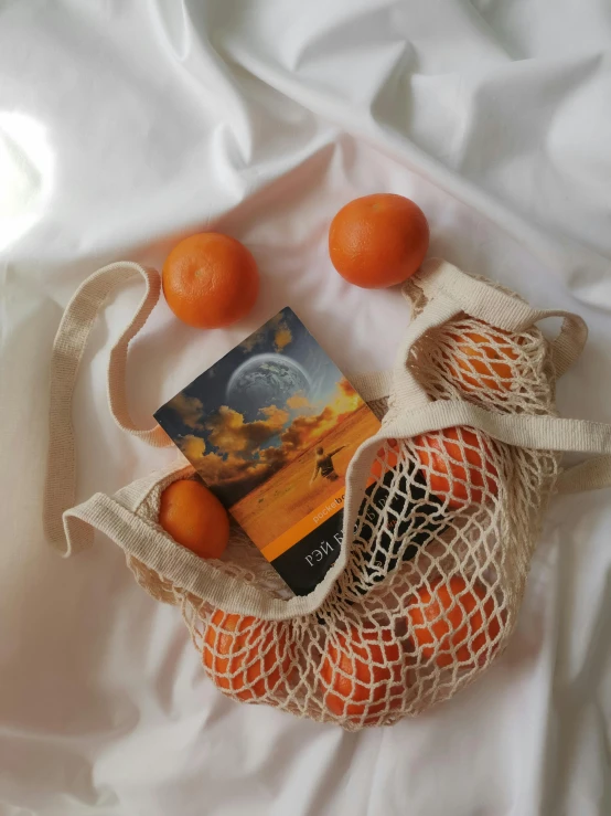 a sack full of oranges and a book on top