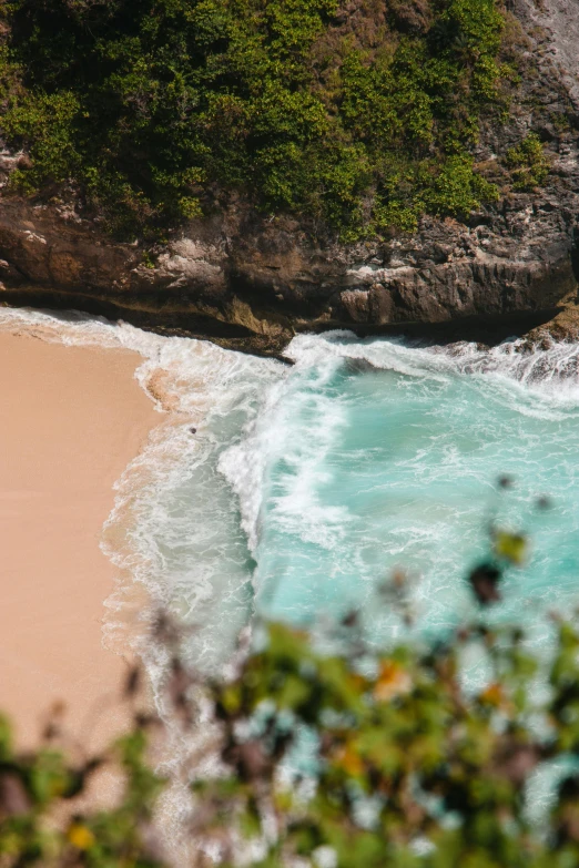 a sandy beach with the ocean waves crashing