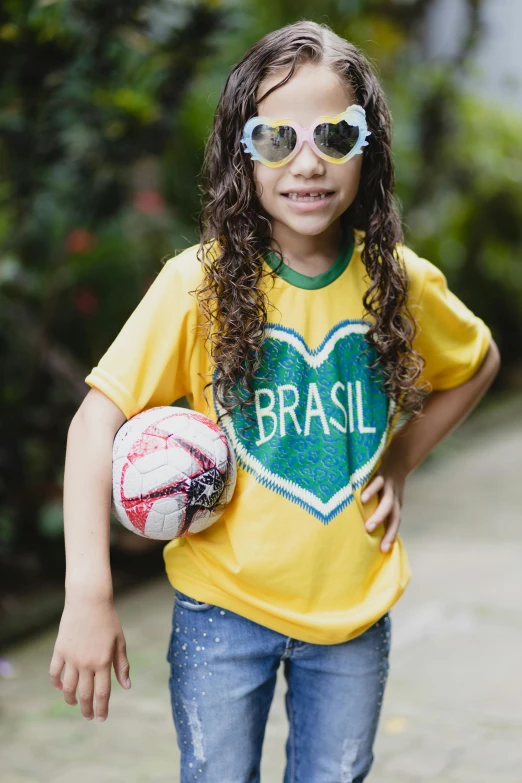 a  in sunglasses and a soccer ball poses for a picture