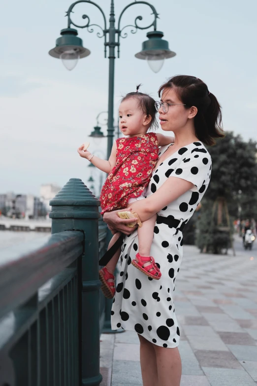 a woman holding a baby in her arms on the street