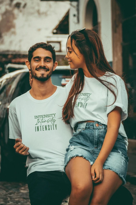 a man sitting on the back of a girl in her shirt