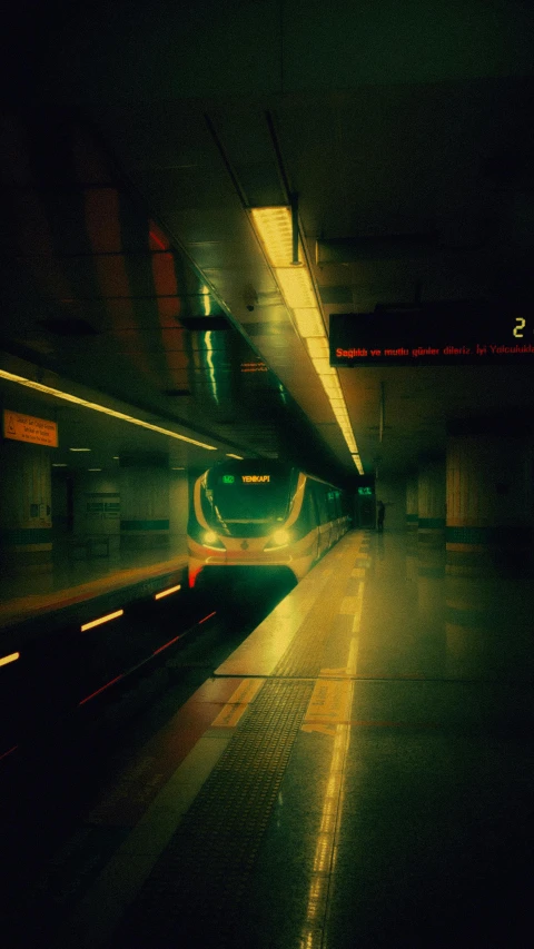 the night is dark and the subway station has a lit up light