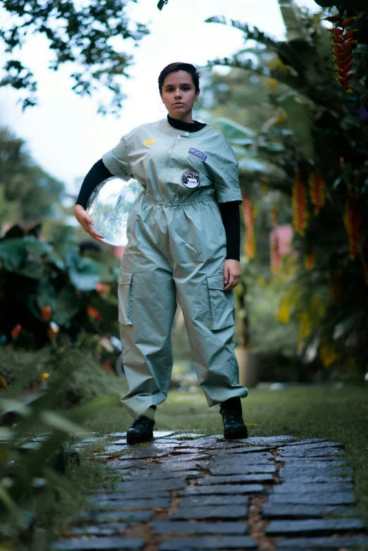 the young woman is standing in front of some trees