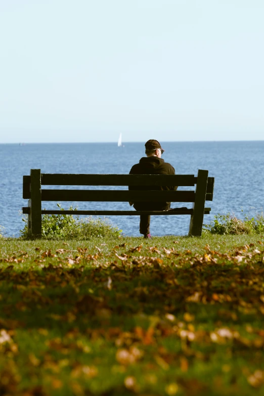 a man sitting on a bench in front of the water