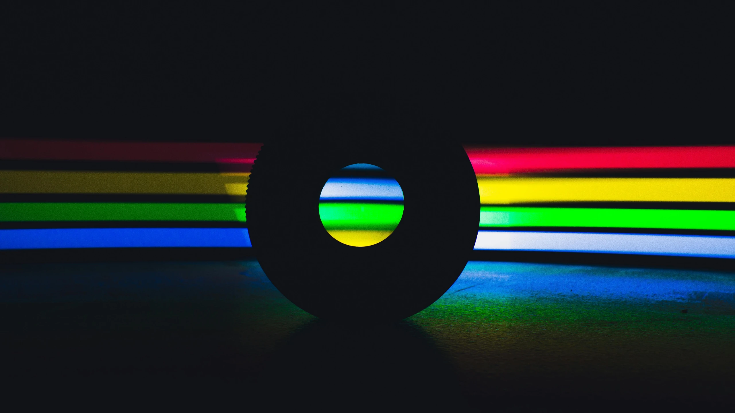 brightly colored lights shine over a black object