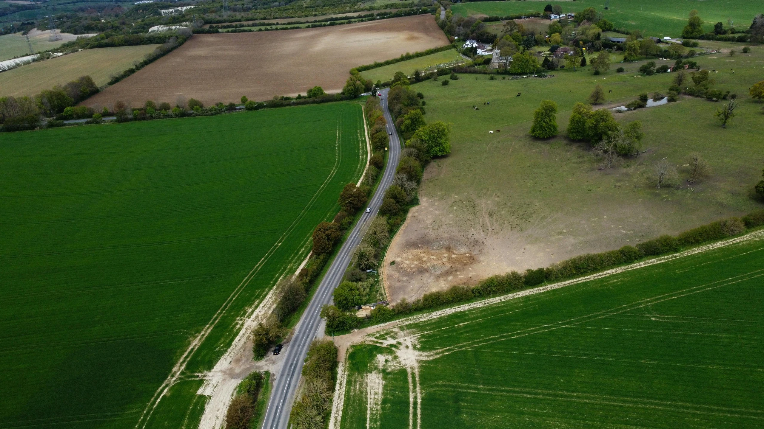 a road runs through the middle of green fields