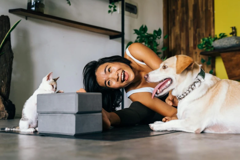 a woman laying on the floor with two dogs